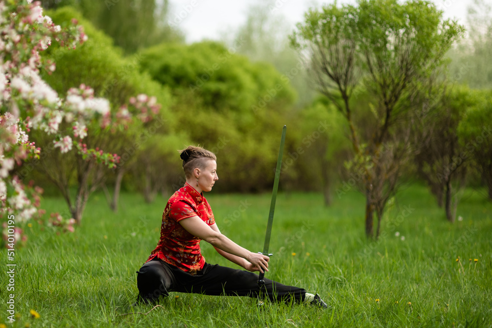 Asian woman with sword training with tai chi in the park, chinese martial arts, healthy lifestyle concept. Asian woman with sword training with tai chi in the park, chinese martial arts, healthy lifestyle concept.