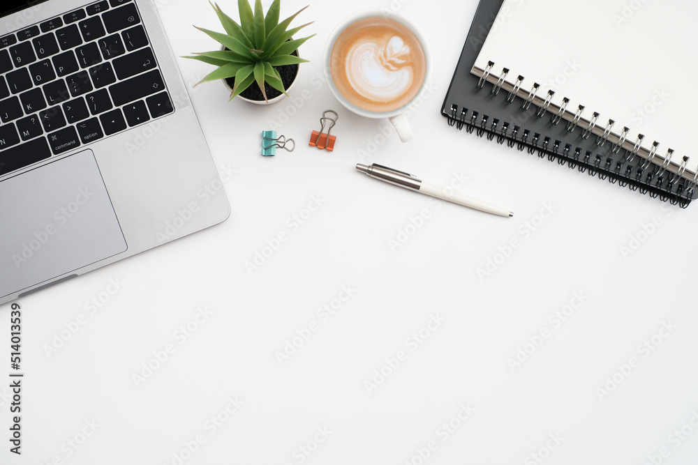 Flat lay, Business office and education concept on white table desk background with laptop computer and coffee cup, blank notepad and stationary,Top view with copy space Flat lay, Business office and education concept on white table desk background with laptop computer and coffee cup, blank notepad and stationary,Top view with copy space