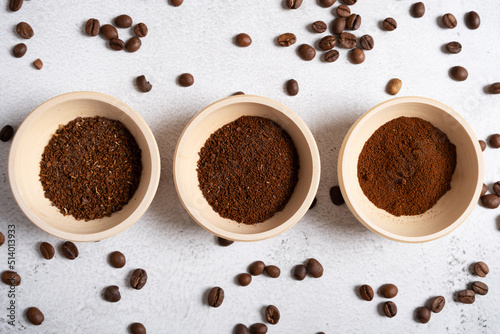 Different degrees of grinding of natural coffee in wooden cups.