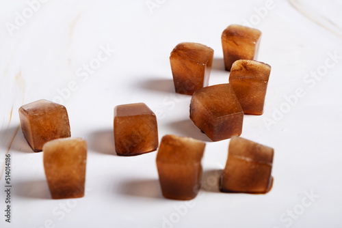 Ice cubes made with coffee on white background. Selective focus