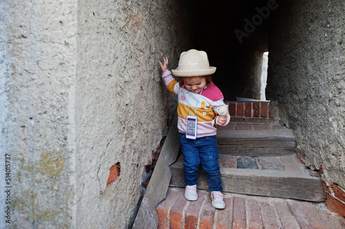 Little baby girl in hat at tower in Veveri castle, Czech Republic.