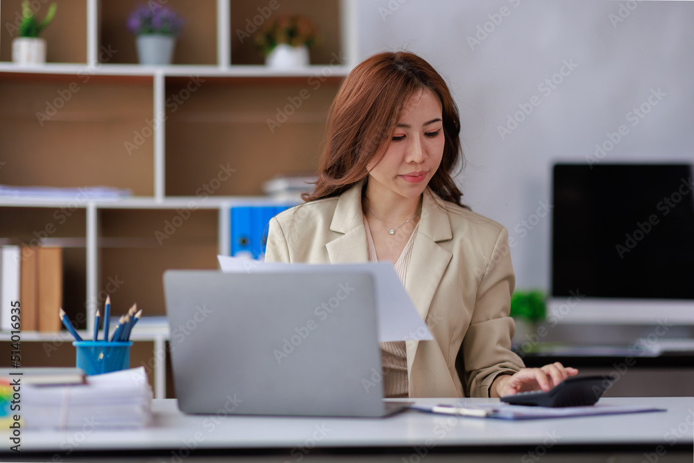 Asian businesswoman working on laptop computer and graph planning a strategy in modern office, Asian woman doing analyzing the financial report, business plan investment, finance analysis concept Asian businesswoman working on laptop computer and graph planning a strategy in modern office, Asian woman doing analyzing the financial report, business plan investment, finance analysis concept