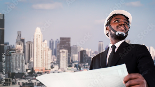 Foto African architect engineer wearing a white helmet stands at a modern building in the background