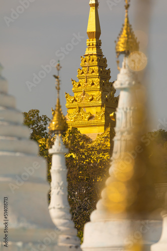 A gilded pagoda gives access to the path up Mandalay Hill, seen through the white stupas of the Sanda Muni Pagoda photo