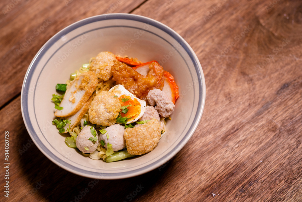Spicy noodle with boiled egg and grilled red pork. Chinese egg noodles topping slice roasted pork, meatballon plate. Spicy noodle with boiled egg and grilled red pork. Chinese egg noodles topping slice roasted pork, meatballon plate.