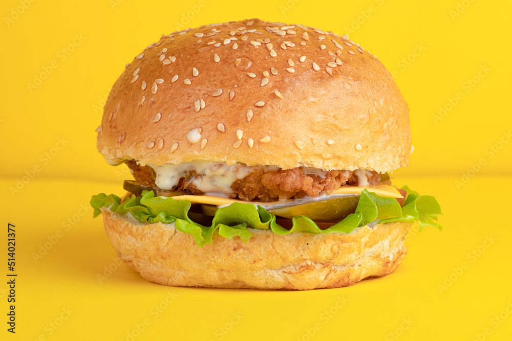 Burger with chicken, on a yellow background, bright background Burger with chicken, on a yellow background, bright background
