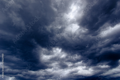 The dark sky with heavy clouds converging and a violent storm before the rain.Bad or moody weather sky and environment. carbon dioxide emissions, greenhouse effect, global warming, climate change.