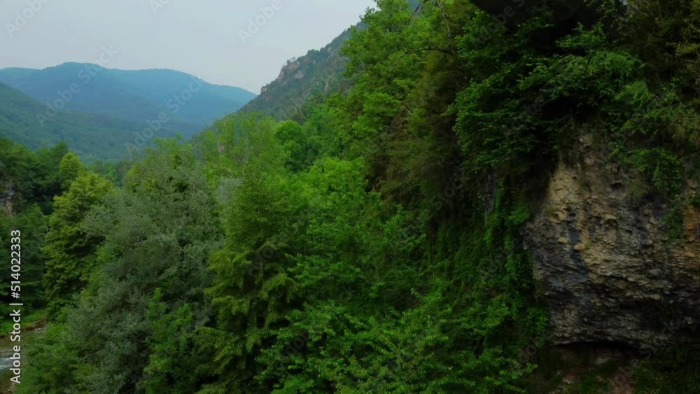 Drone in the italian alps climbing over a bridge with a couple standing on top of it Drone in the italian alps climbing over a bridge with a couple standing on top of it