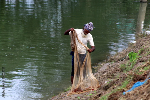 An old age Fisherman is fishing by net.Daily lifestyle of Village people.