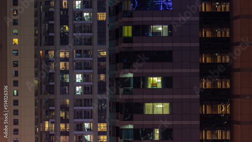 Night night view of multicolor light in windows of multistory buildings aerial timelapse.