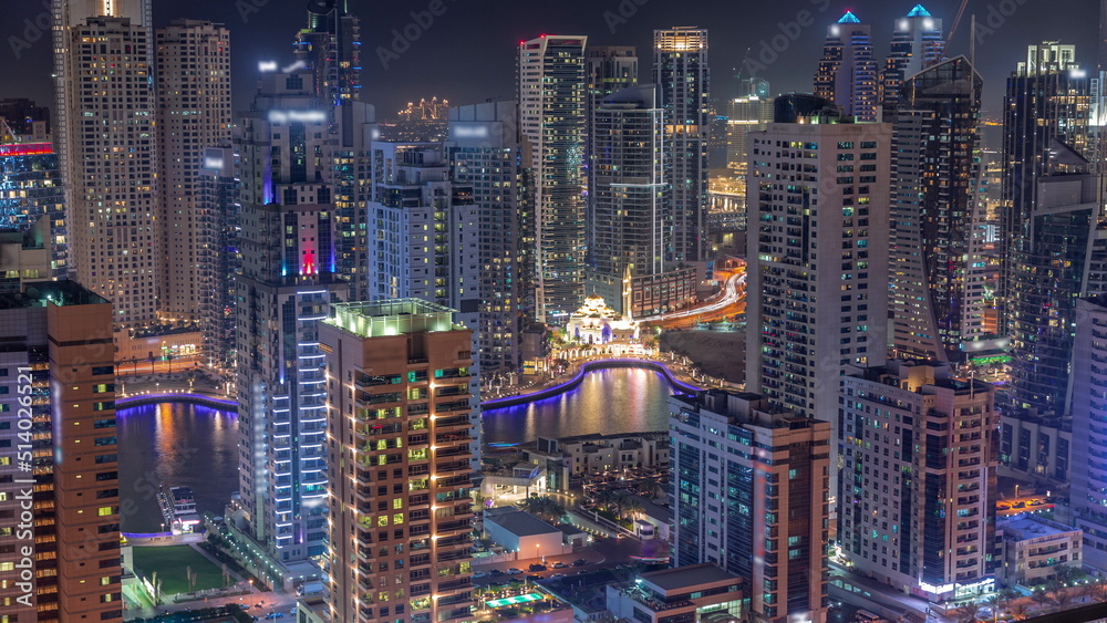Obraz premium Dubai Marina skyline with Mohammad Bin Ahmed Al Mulla mosque aerial timelapse at night.