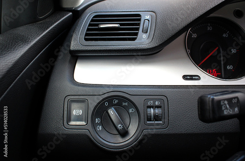 Car interior with light switch, automatic control of switching on and off the car light and Air ventilation grille with power regulator. Dashboard for switching on the headlights and fog lights.
