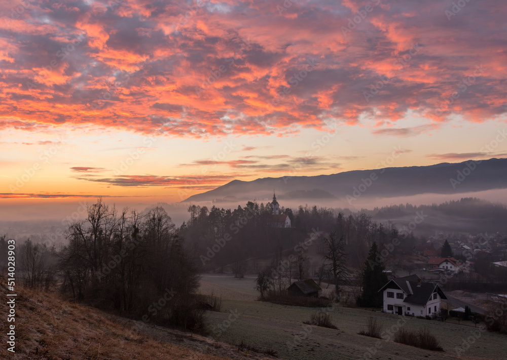 Vivid sunrise over the church on a misty morning on Bled Vivid sunrise over the church on a misty morning on Bled