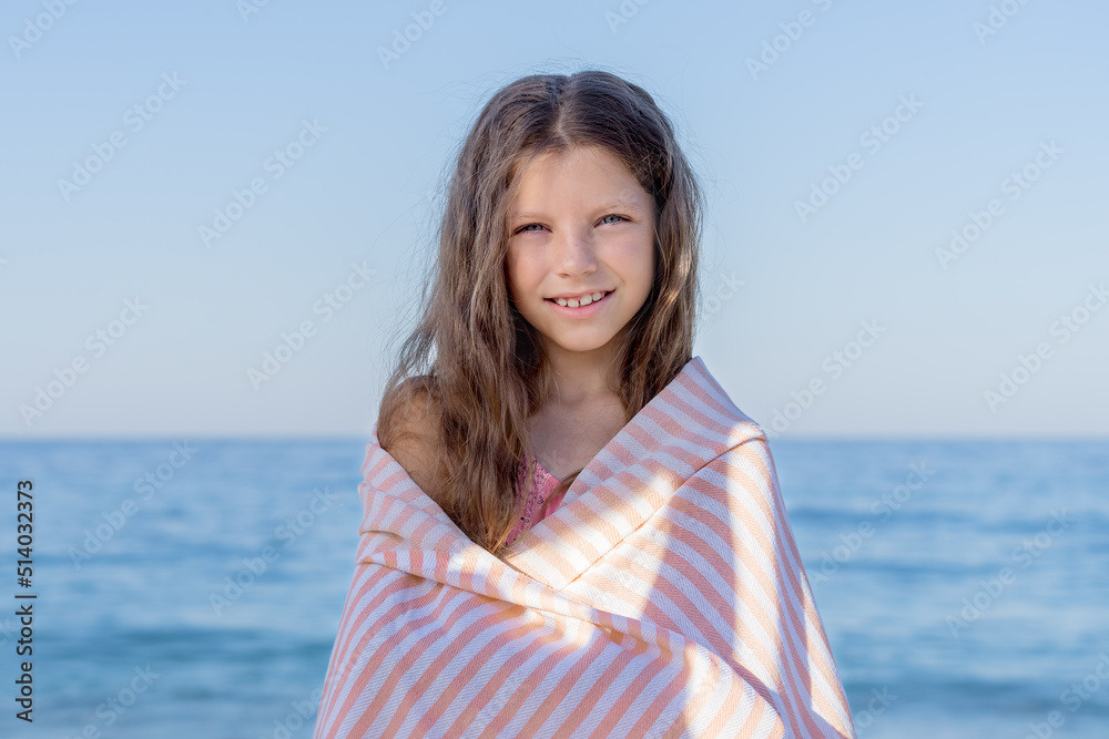 Portrait of a girl wrapped in a towel against the blue sky and the sea. Portrait of a girl wrapped in a towel against the blue sky and the sea.