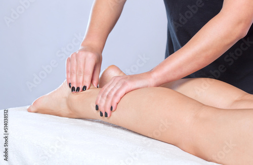 An orthopedic doctor does massage of the foot and lower leg of the patient after an injury in the clinic.Cosmetology and massage concept.Cosmetology and massage concept.