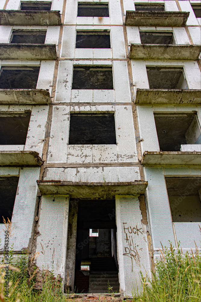 A damaged abandoned panel house with decorative facade of small white tiles. A damaged abandoned panel house with decorative facade of small white tiles.