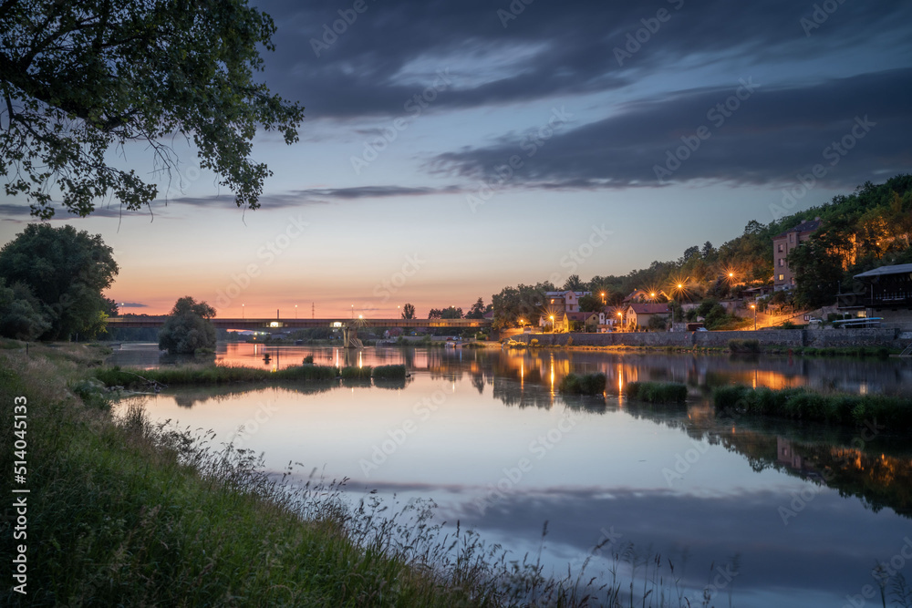 Old bridge over Labe in summer Melnik city in the night with lights, view from the river