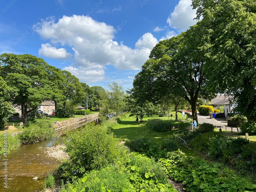 View over the, River Aire, with wild plants and trees nearby, as it flows gently through Gargrave, UK