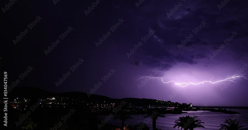 Lightning storm over Adriatic sea. Sky with lightning bolt and silhouette of a cityscape at night. Bar, Montenegro
