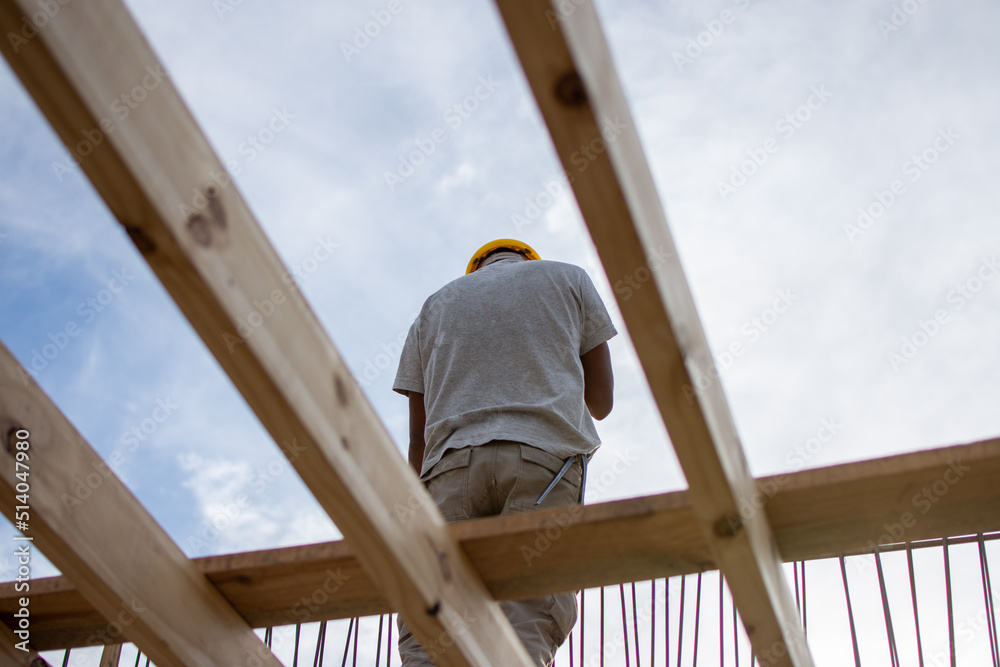 male builder performs work on the roof, fastens corrugated sheets male builder performs work on the roof, fastens corrugated sheets