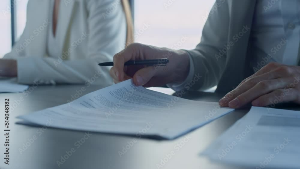 Closeup hands checking agreement in office. Business partners reading contract