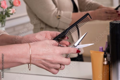  Hairdresser hands holding scissors for haircut and brush in hairdressing salon
