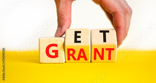 Get grant symbol. Businessman turns wooden cubes with concept words Get grant on a beautiful yellow table white background. Copy space. Business and get grant concept. photo
