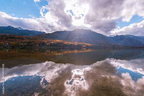 Autumn landscape by the lake Bohinj in Julian Alps. Fascinating reflectins in the lake on a cloudy day. photo