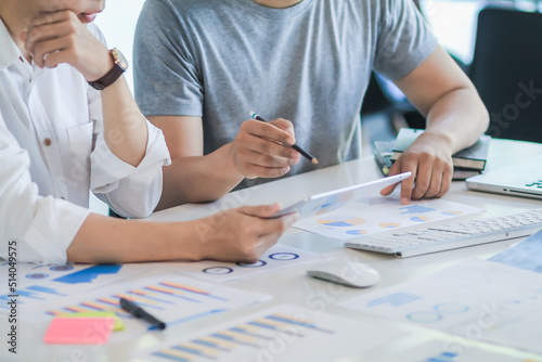 group of startup entrepreneurs who are investing together are studying marketing and planning their investments to get best return for them and listening to advice from an investment advisor. photo