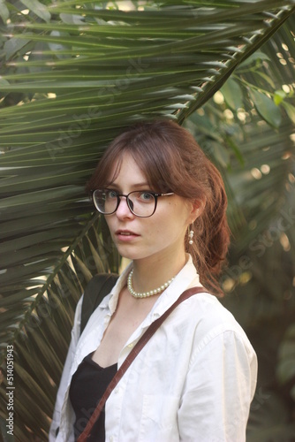 Portrait of a girl with green tropical leaves