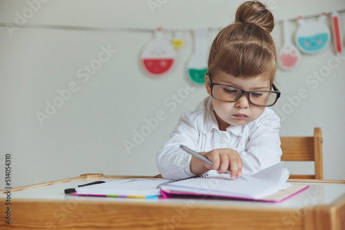 Charming child plays pretending to be a teacher photo