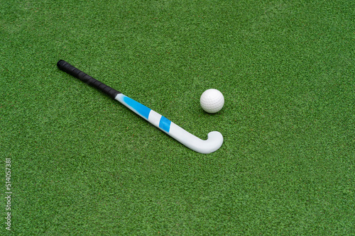 Field hockey stick and ball on green grass. Horizontal sport theme poster, greeting cards, headers, website and app.