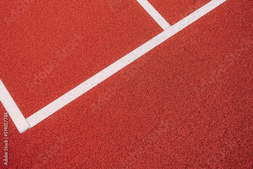 Colorful sports court background. Top view to red field rubber ground with white lines outdoors