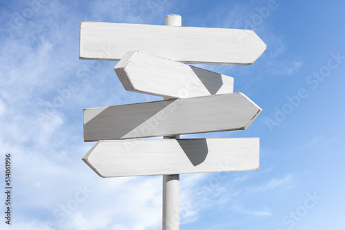 Blank white signpost on blue sky background. Choose the correct way concept. Mock up, template photo