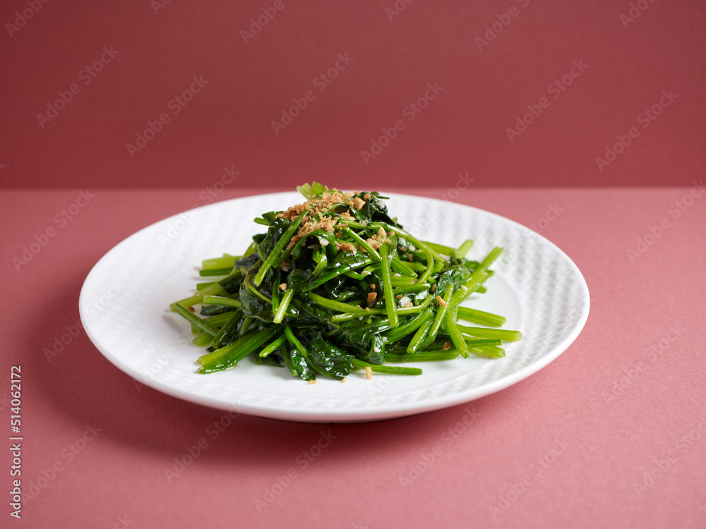 Stir-Fried Spinach with Garlic with chopsticks served in a dish isolated on mat side view on grey background Stir-Fried Spinach with Garlic with chopsticks served in a dish isolated on mat side view on grey background