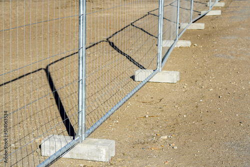 Temporary metallic portable fence with concrete base blocks to limit the territory photo