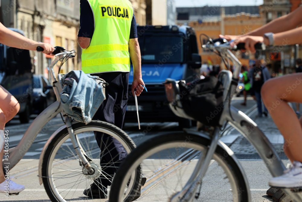 Policjant ruchu drogowego z lizakiem do zatrzymywania pojazdów w mieście kontroluje ruch na zabezpieczeniu.  - obrazy, fototapety, plakaty 