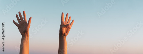 Woman hands showing or doing number nine gesture on blue summer sky background. Counting down, nine fingers up concept idea. Large copy space for text for displays, prints, advertising banners. photo