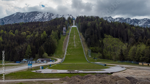  Ski jumping hill in Kulm, Austria, close to Tauplitz. Aerial view of a well known ski jumping area viewed from a drone in a cloudy day.