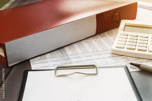 a red folder and a white calculator on the financial document. Business and financial concept