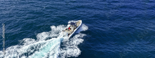 Aerial drone ultra wide photo with copy space of luxury rigid inflatable speed boat cruising in high speed in Aegean deep blue sea, Greece © aerial-drone