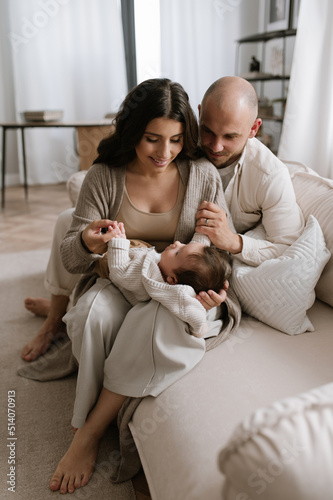 Mother and father holding their infant in minimalism interior small cute baby and stylish family with modern look