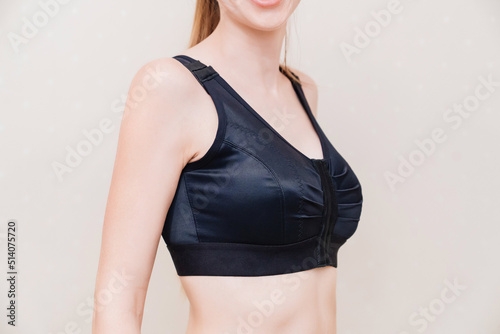 A young woman in black compression underwear after mammoplasty. photo