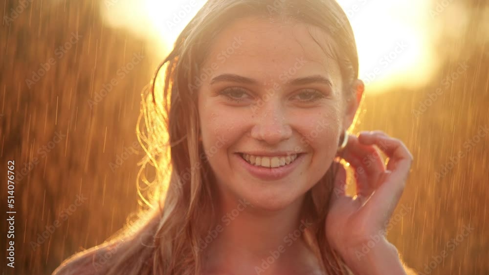 Portrait of Happy smiling woman stay outside under rain drops in the
