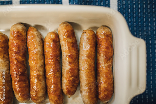 Принти на полотні browned, cooked individual breakfast sausage links in white dish on blue and whi