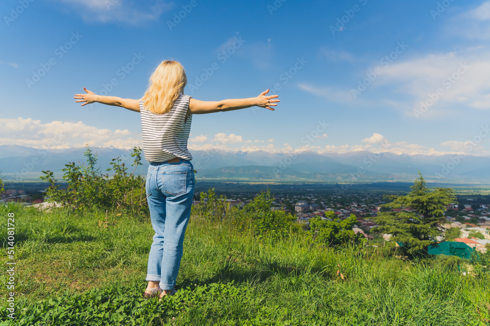 blond girl with outstretched hands on a marvelous view of Alazani valley and Caucasus mountains in Georgia. full shot. High quality photo blond girl with outstretched hands on a marvelous view of Alazani valley and Caucasus mountains in Georgia. full shot. High quality photo