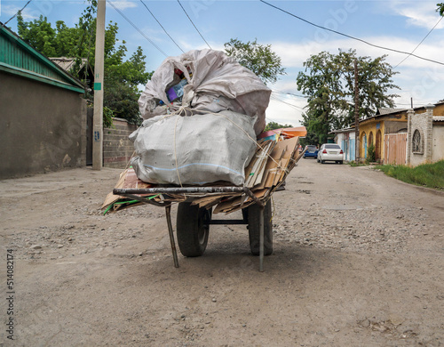 A cart with a load in the middle of the street.