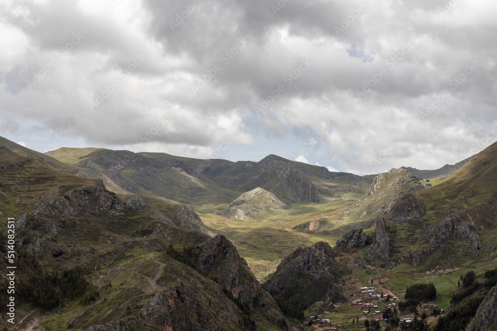 HUANCAVELICA, PERU - JUNE 29, 2022: Beautiful panoramic view of some rocky mountains partially covered with vegetation. View of the sky with enough clouds that shaded the landscape.