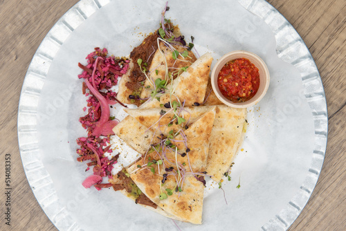 Overhead view of nutritious cheese quesadilla with BBQ jerk jackfruit on a tortilla will start any day with a nutrional boost photo