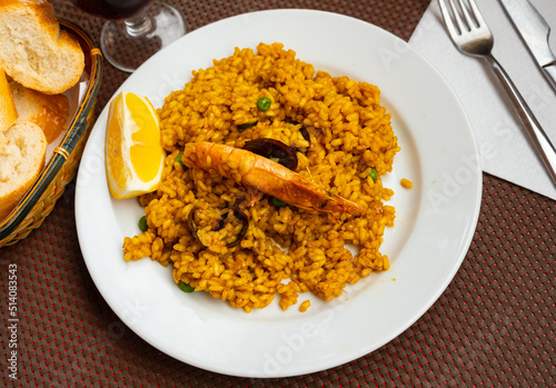Traditional paella marinera with shrimps and mussels served on iron frypan